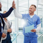 Healthcare hiring team celebrating with medical staff in a hospital after successful screening and credentialing.
