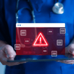 Doctor holding tablet with red warning alert on medical data interface