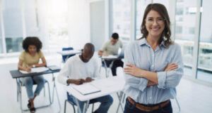 Education, portrait and woman professor in a classroom with students for teaching, knowledge and motivation.
